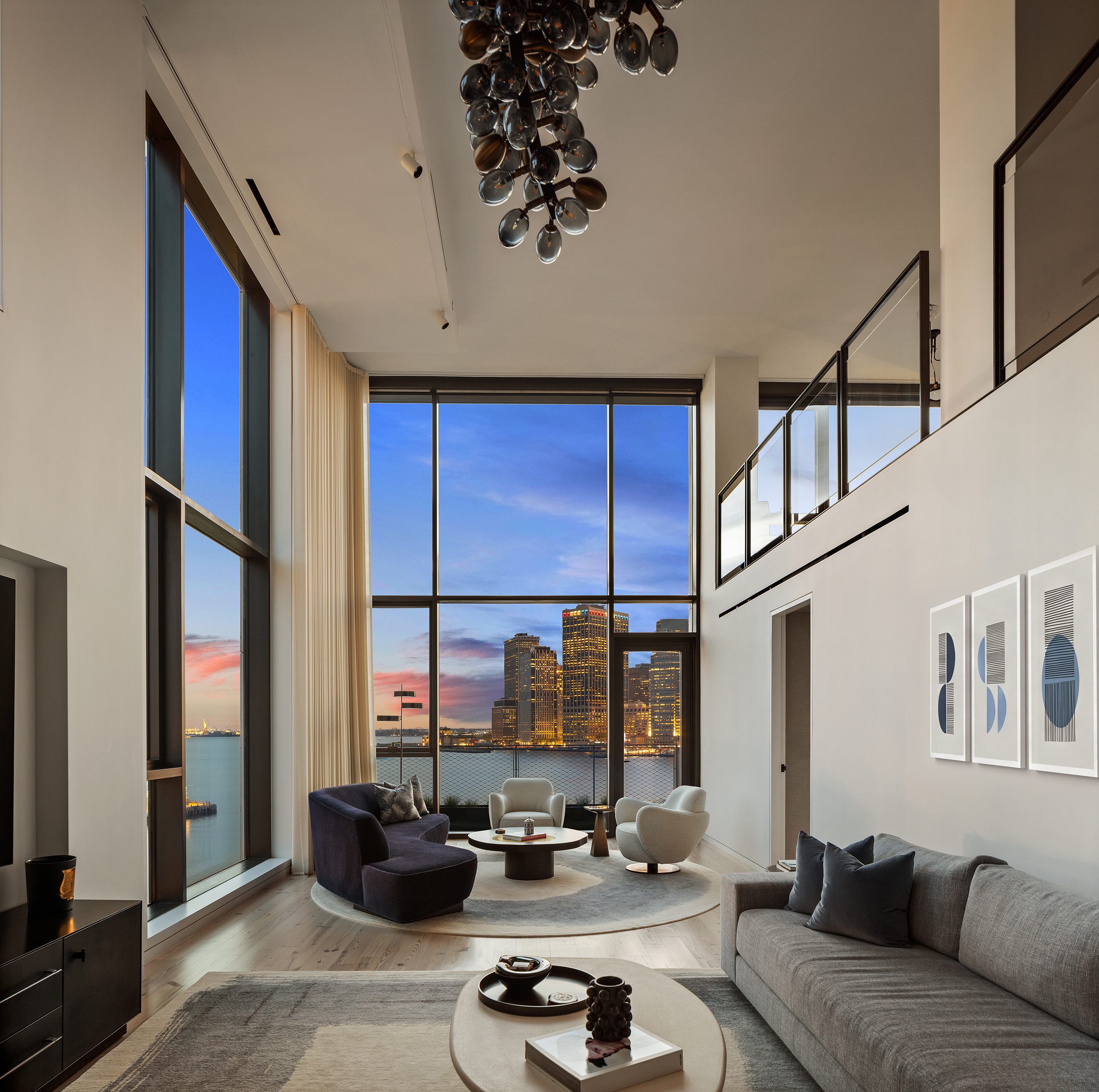 90 Furman — double-height living room at dusk