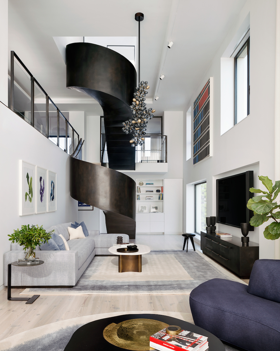Double-height living room with staircase and chandelier