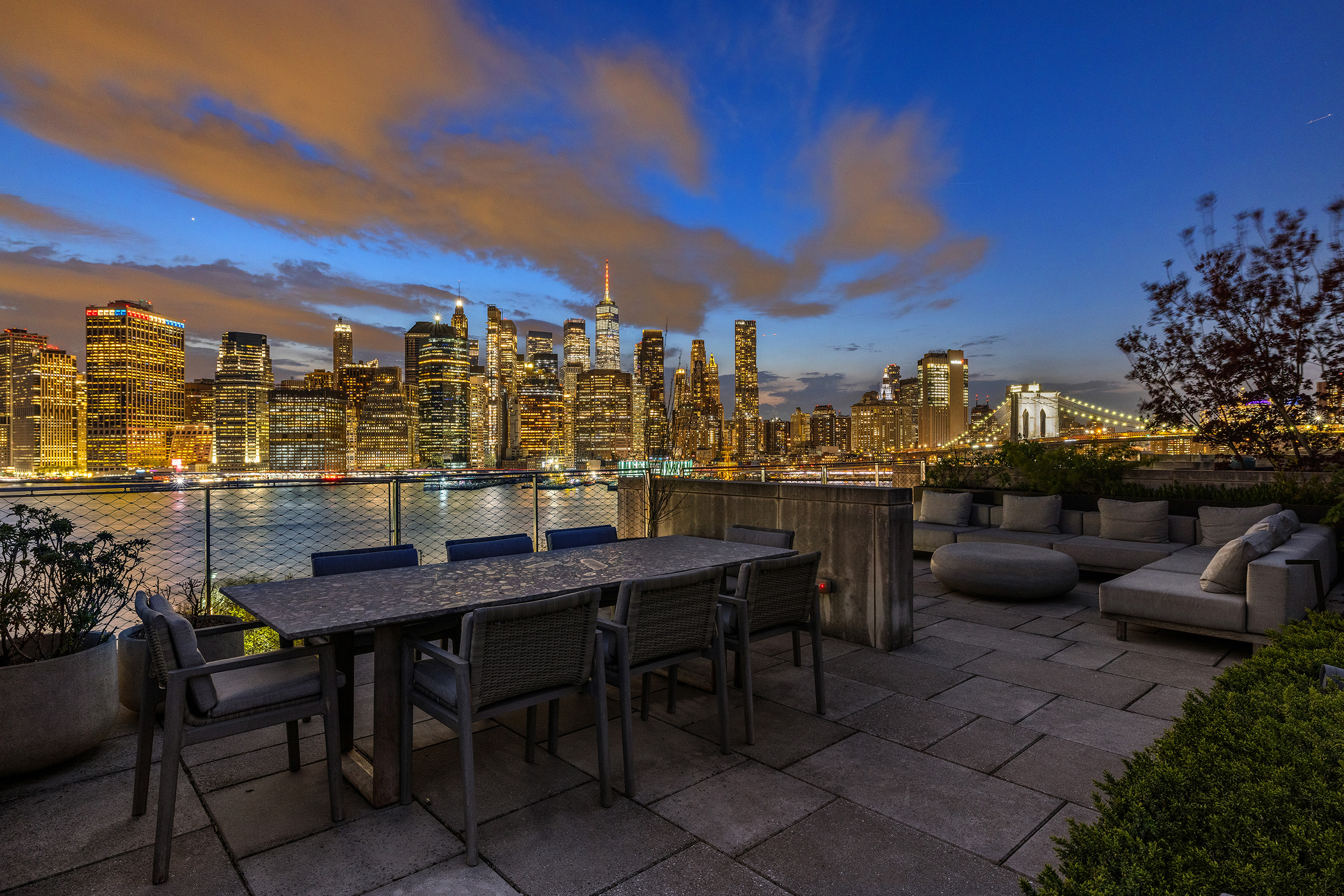 Private rooftop terrace at night with Manhattan and Brooklyn Bridge